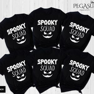 May include: Black t-shirts with the text "SPOOKY SQUAD" in white, featuring a jack-o'-lantern face. The shirts are short-sleeved and suitable for Halloween. The brand name "PEGASUS ApparelUS" is visible in the top right corner.