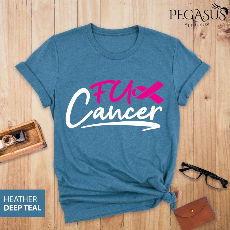 May include: A teal blue t-shirt with the text "F*ck Cancer" in white with a pink ribbon.