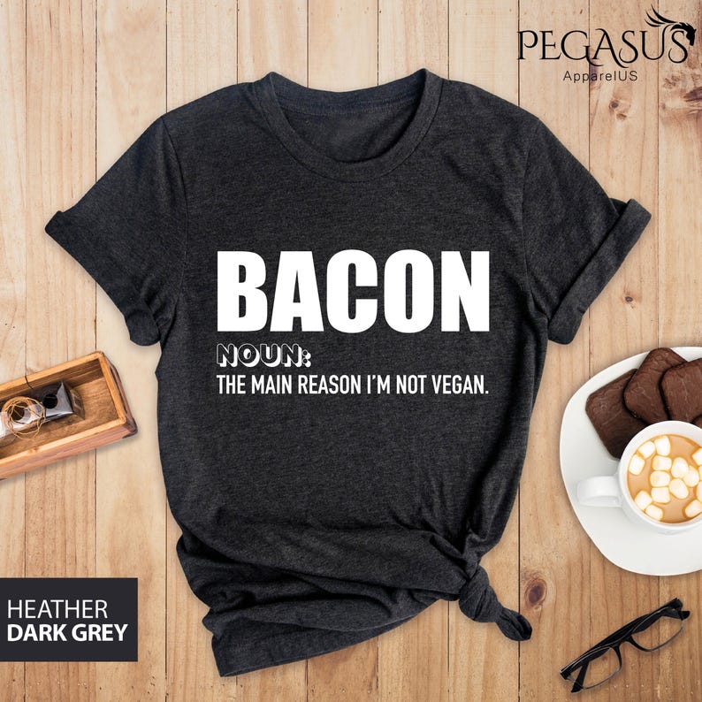 May include: Dark heather grey t-shirt with white text that reads "BACON NOUN: THE MAIN REASON I'M NOT VEGAN."