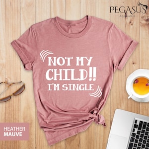 May include: A heather mauve t-shirt with the text "Not My Child!! I'm Single" printed in white.