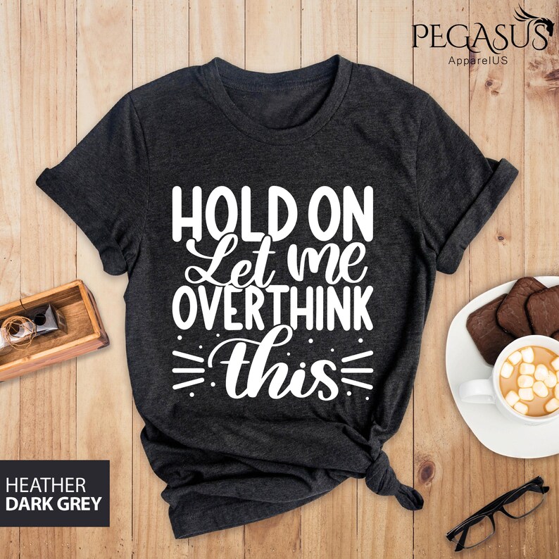 May include: Dark heather grey t-shirt with the text "Hold on let me overthink this" in white.