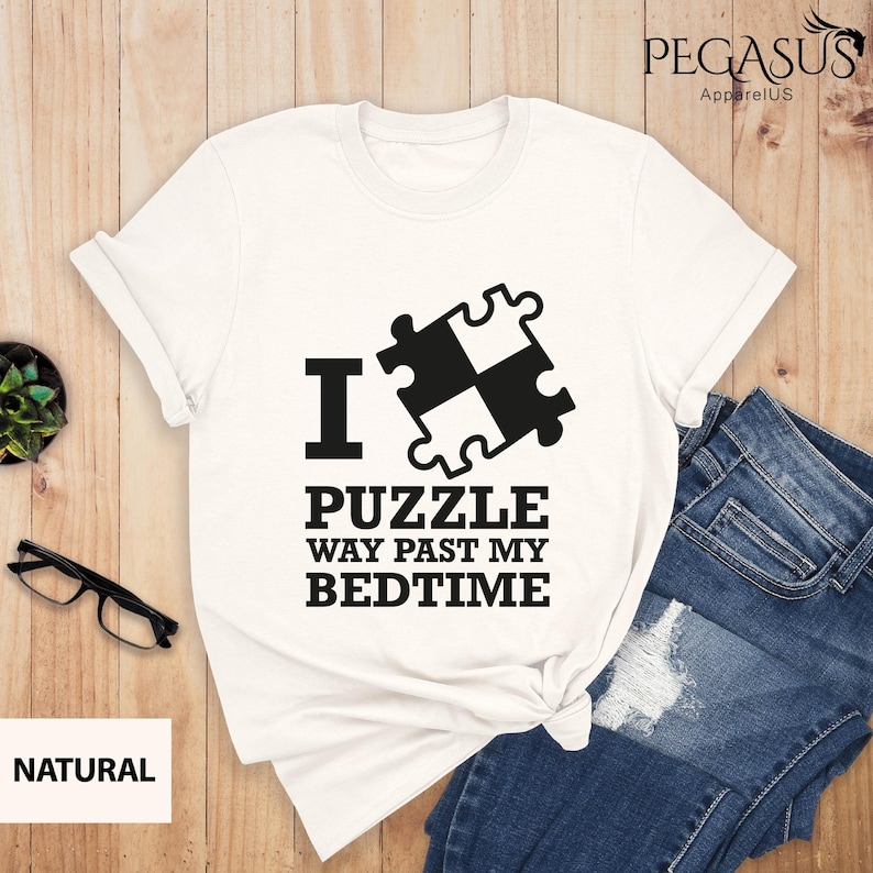 Puede incluir: Camiseta blanca con texto negro y un gr&aacute;fico de pieza de rompecabezas. El texto dice "Me encanta el rompecabezas mucho m&aacute;s all&aacute; de mi hora de acostarme".
