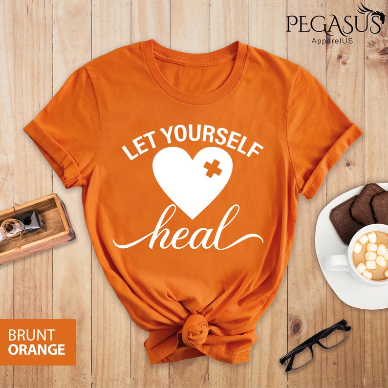 May include: Orange t-shirt with the text "Let Yourself Heal" and a white heart with a bandage on it.