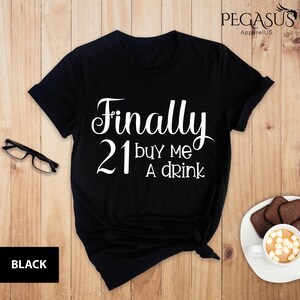 May include: Black t-shirt with white text that reads "Finally 21 buy me a drink".