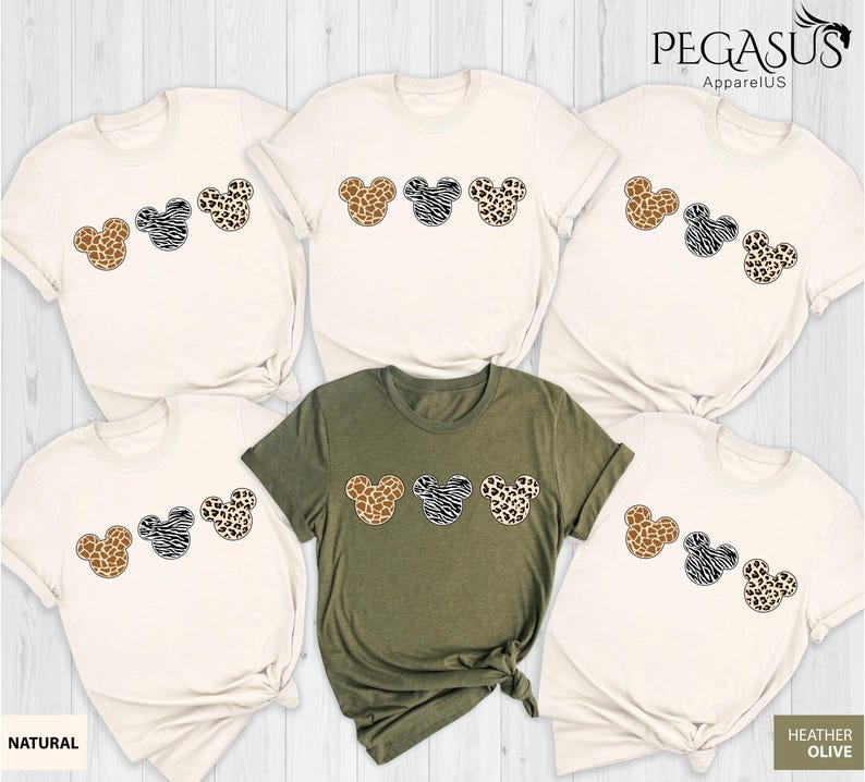 May include: Set of six t-shirts featuring a row of three cartoon Mickey Mouse heads with different animal print patterns. The shirts are in natural and heather olive colors. The text "Pegasus ApparelUS" is in the top right corner of the image.