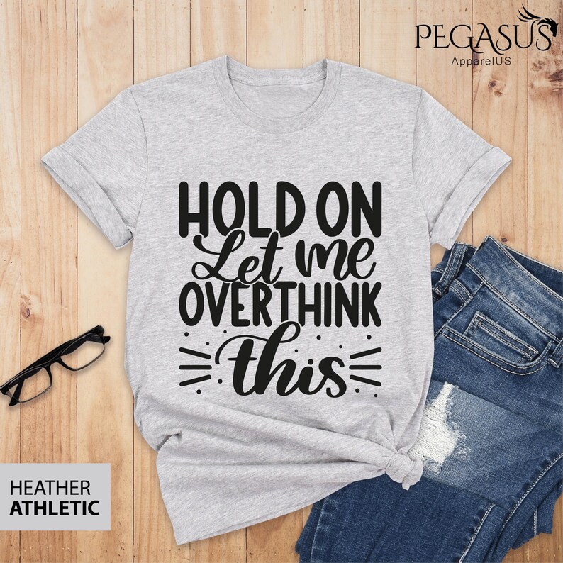 May include: Gray t-shirt with black text that reads "Hold on Let me overthink this".