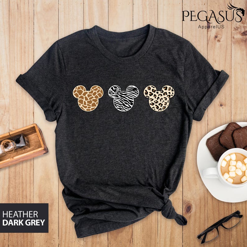 May include: Heather dark grey t-shirt with three Mickey Mouse ears in a row. The ears are printed with different animal prints: giraffe, zebra, and leopard.