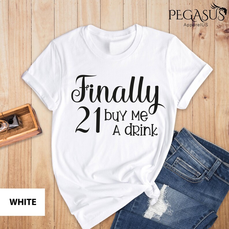 May include: White t-shirt with black text that reads "Finally 21 buy me a drink".
