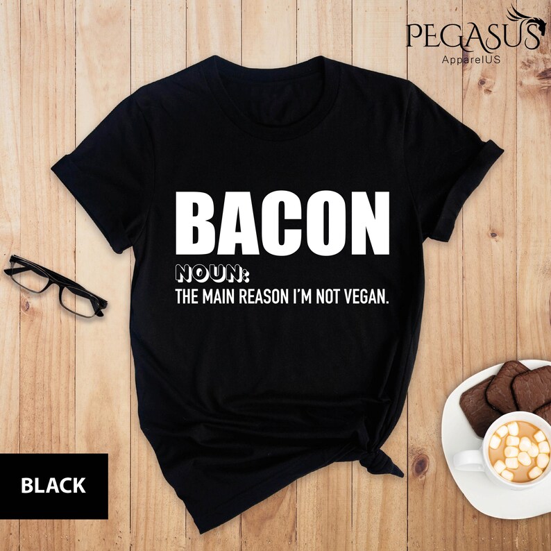 May include: Black t-shirt with white text that reads "BACON NOUN: THE MAIN REASON I'M NOT VEGAN."