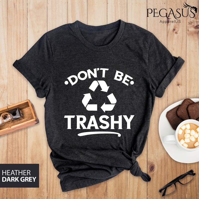 May include: Dark heather grey t-shirt with a white graphic that says "Don't Be Trashy" with a recycling symbol.