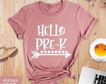 May include: A heather mauve t-shirt with the text "Hello Pre-K" and a white arrow with dots above it.