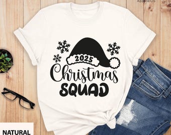 May include: White t-shirt with a black Santa hat graphic and the text "2025 Christmas Squad".