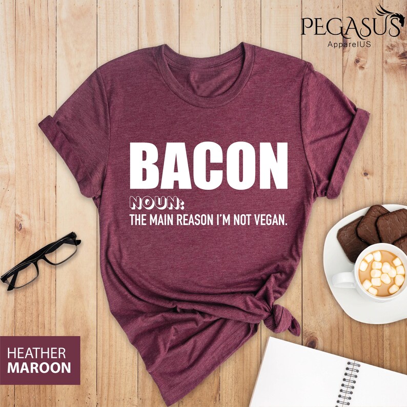 May include: A maroon t-shirt with the text "BACON NOUN: THE MAIN REASON I'M NOT VEGAN." printed in white.