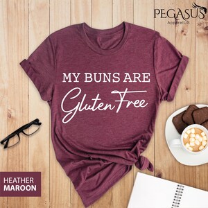 May include: Heather maroon t-shirt with the text "My buns are gluten free" in white.