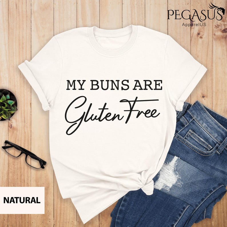 May include: White t-shirt with the text "My Buns Are Gluten Free" in black lettering.