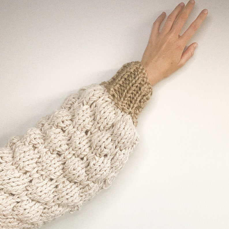 close up image of the sleeve. this chunky knitted cardigan sleeve is made using the bubble stitch and 1x1 rib stitch