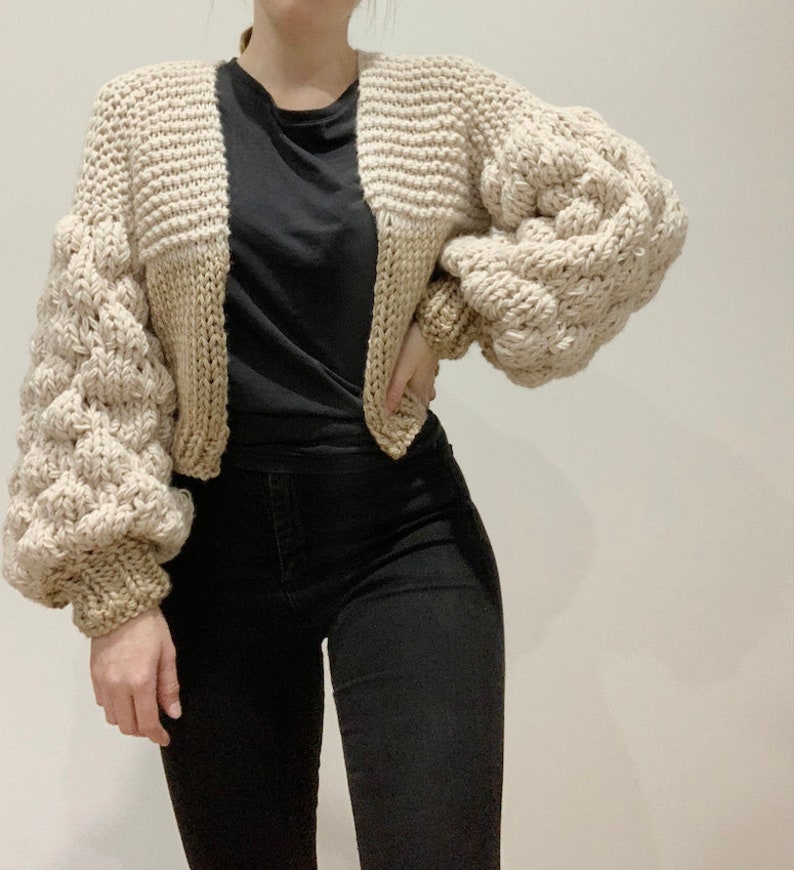 Bubble Sleeve chunky knit cropped cardigan. uses 12mm and 15mm needles to achieve chunky over sized look. the sleeves are made up of a 1x1 rib knit cuff and bubble stitch bubble sleeve. the body is made up of half knit stitch and half stocking stitch