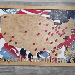 May include: Wooden football stadium map of the United States, featuring a laser-cut design with stadium locations marked by red footballs. The map includes the text "Football Stadium Map" and is framed in a natural wood finish.