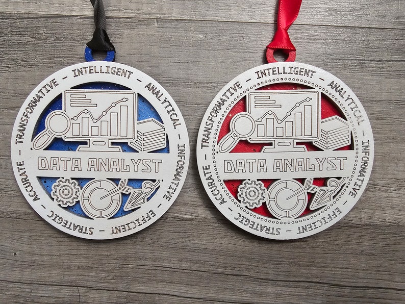 May include: Two circular ornaments featuring a white cutout frame with the text DATA ANALYST and descriptors like INTELLIGENT, ANALYTICAL, INFORMATIVE, EFFICIENT, STRATEGIC, ACCURATE, and TRANSFORMATIVE. One has a blue glitter background, the other red.