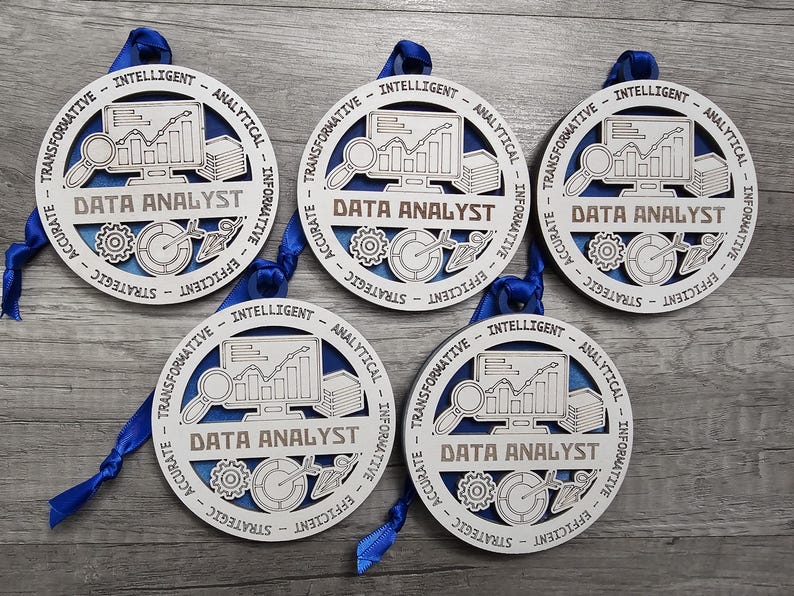 May include: Five circular wooden ornaments featuring a blue background and white laser-cut overlay. Each ornament displays a computer monitor with a graph, a magnifying glass, gears, and the text DATA ANALYST, surrounded by words like INTELLIGENT.