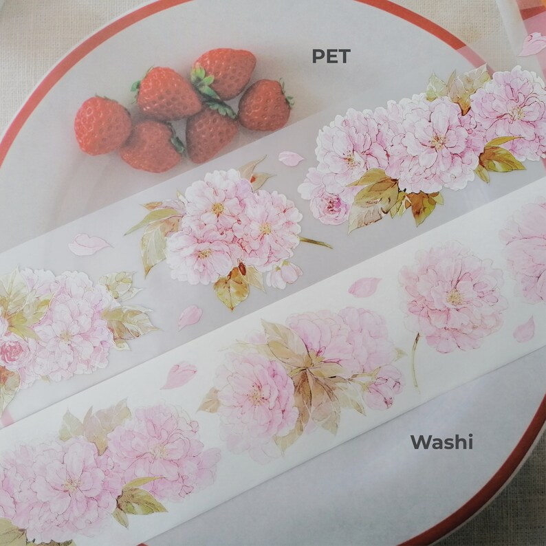 May include: Two rolls of decorative tape with a floral design. The top roll is labeled "PET" and the bottom roll is labeled "Washi".