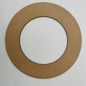 May include: A brown cardboard wreath form with a black inner ring. The wreath form is circular and has a smooth surface.