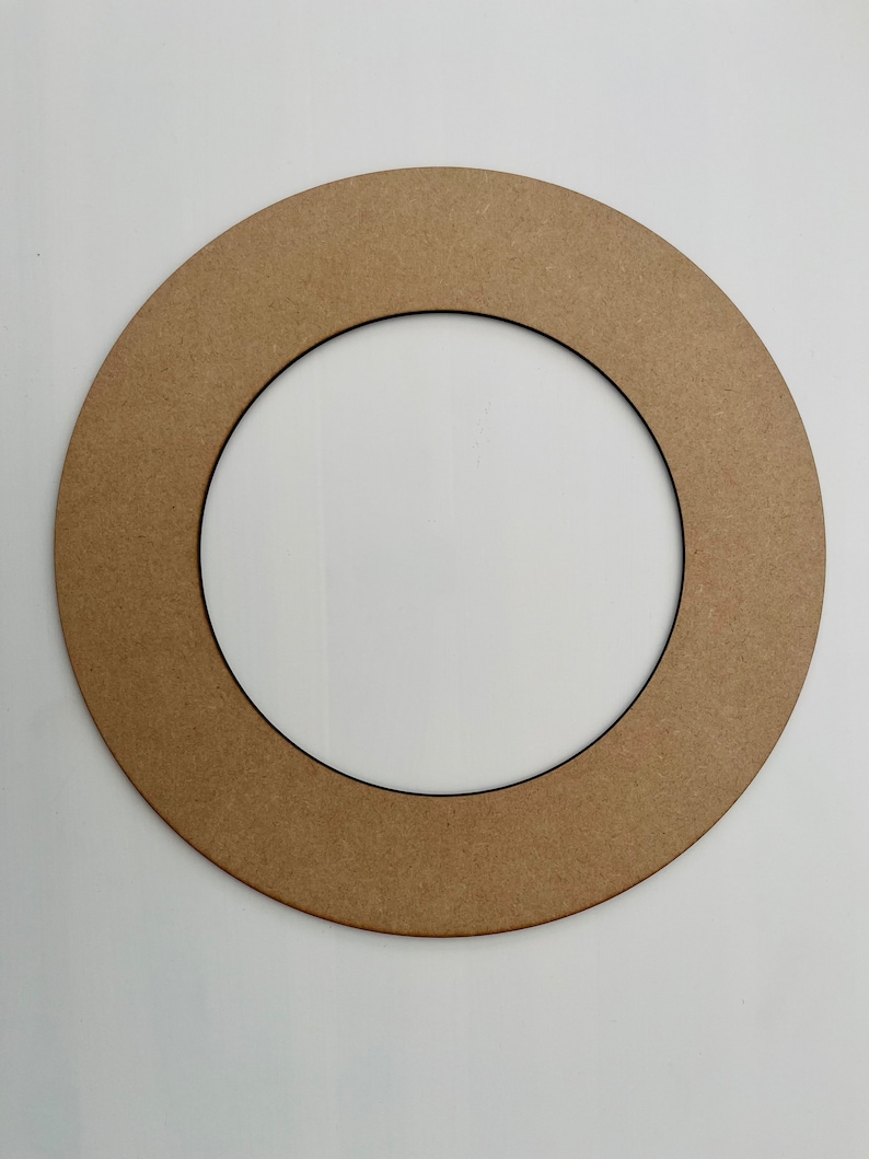 May include: A brown cardboard wreath form with a black inner ring. The wreath form is circular and has a smooth surface.