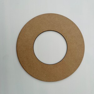 May include: A brown cardboard ring with a smaller circle cut out in the center. The ring is about 10 inches in diameter.