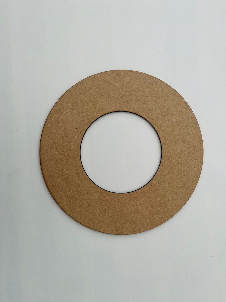 May include: A brown cardboard ring with a smaller circle cut out in the center. The ring is about 10 inches in diameter.