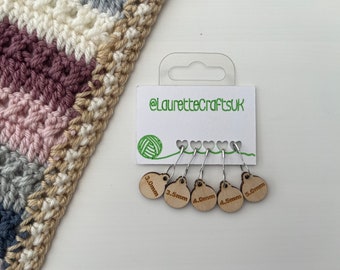 May include: Set of five wooden stitch markers with metal rings. Each marker is round and has a different size printed on it: 3.0mm, 3.5mm, 4.0mm, 4.5mm, and 5.0mm. The markers are packaged on a white card with the text "@laurettecraftsuk" printed on it.