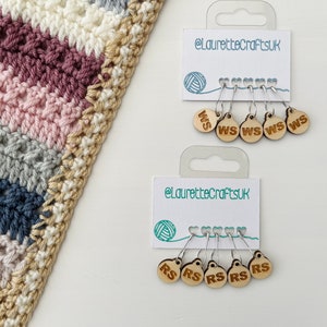 May include: Two sets of wooden stitch markers with metal loops. The first set has five markers labelled "WS" for "wrong side". The second set has five markers labelled "RS" for "right side".