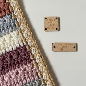 May include: Two wooden tags with the text "Made with Love" and a small yarn ball and heart symbol. The tags are on a white background.