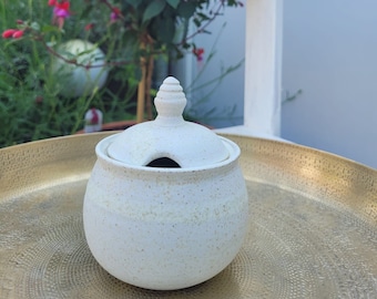 Sugar bowl, bulbous and beige. Created on the potter's wheel in the ceramic studio. Cutout in the lid for a spoon. handmade.