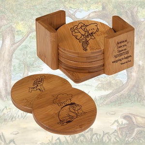 May include: Set of six bamboo coasters featuring Winnie the Pooh and Piglet characters. The coasters are engraved with images of the characters and a quote from the book. The coasters come with a bamboo holder.