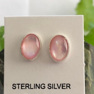 May include: A pair of sterling silver earrings with pink oval-shaped mother of pearl stones.