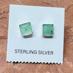 May include: A pair of sterling silver earrings with square green stones.