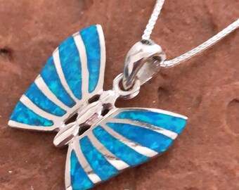 May include: A silver chain necklace with a blue opal butterfly pendant. The butterfly has a detailed design with silver accents.