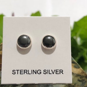 May include: A pair of sterling silver stud earrings with black round stones.