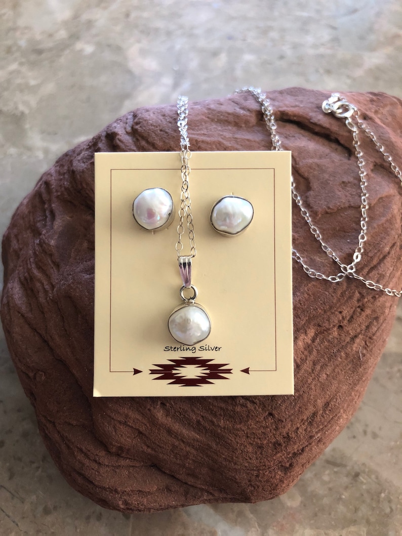 May include: A white pearl necklace and earrings set with sterling silver chain and posts. The pearls are irregular in shape and have a natural, organic look.
