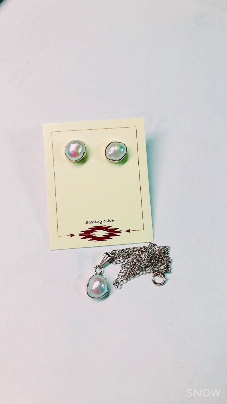 May include: A set of pearl earrings and a pearl pendant necklace. The earrings and pendant are made of sterling silver and feature a white pearl.
