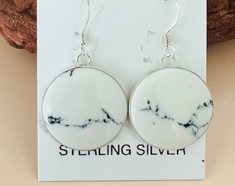 May include: A pair of white and black marble earrings with sterling silver hooks. The earrings are round and have a marbled pattern.