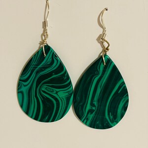 May include: A pair of green malachite teardrop earrings with silver hooks.