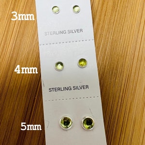 May include: Three pairs of sterling silver stud earrings with green stones. The earrings are displayed on a white card with the sizes 3mm, 4mm, and 5mm printed below each pair.