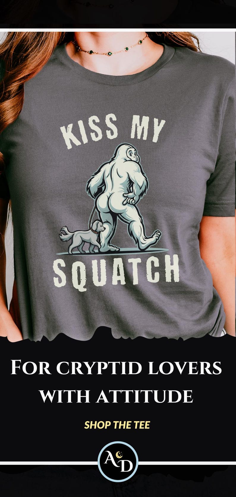 May include: Dark gray t-shirt with a humorous graphic of a Bigfoot walking a dog, with the text "KISS MY SQUATCH". Below the graphic, the text reads "FOR CRYPTID LOVERS WITH ATTITUDE".