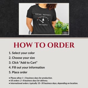 May include: A black short-sleeved t-shirt featuring a white graphic of a fuel gauge labeled SOCIAL BATTERY with a ghost icon at the empty mark and the word DECEASED printed below the gauge. The design is centered on the chest of the garment.