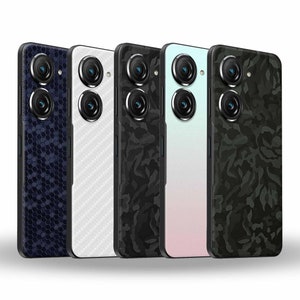 May include: Five different phone cases with various patterns. The cases are black, white, camouflage, pink, and blue. The cases are all for the same model phone and have a similar design.