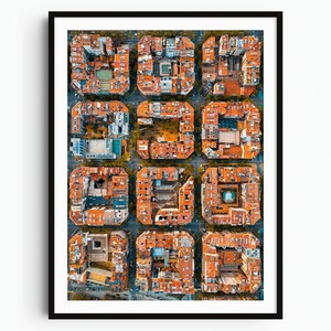 May include: A framed aerial photograph of a city grid featuring twelve distinct square city blocks. Each block consists of buildings with orange-red rooftops arranged around central courtyards, separated by narrow gray streets in a geometric pattern.