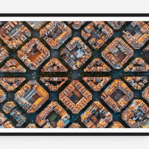 May include: An aerial view of a city with a grid-like pattern of buildings. The buildings are all the same size and shape, and they are arranged in a symmetrical pattern. The buildings are a mix of red, orange, and brown, and they are surrounded by green trees.