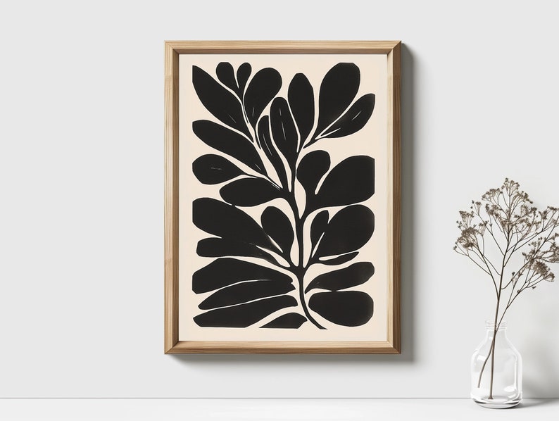 Op de afbeelding: Zwart-witte abstracte kunstprint van een gestileerde plant met grote bladeren. De print is ingelijst in een licht houten lijst.