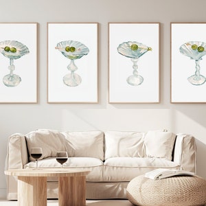 May include: Set of four watercolor paintings of martini glasses with green olives. Each painting features a different angle of the glass.